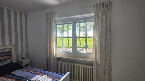 a bedroom with a bed and a large window at Ferienwohnung MOIN in Osdorf