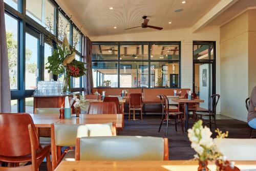 ein Restaurant mit Tischen, Stühlen und Fenstern in der Unterkunft The Gladdy in Stockton