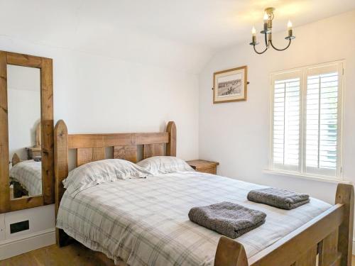 a bedroom with a large bed and a mirror at Springwell , West Wittering in West Wittering