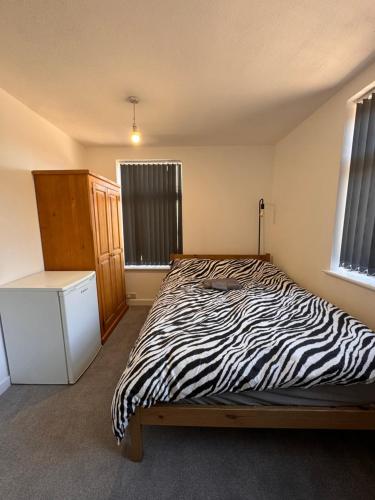 a zebra print bed in a room with windows at Serenity LTD in Leicester