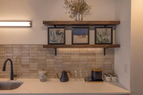 a kitchen counter with a sink and a shelf with pictures at The Promissory Hotel in Roanoke