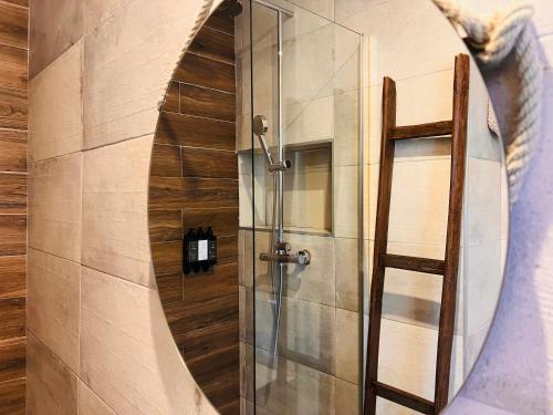 a shower in a bathroom with a round mirror at Oryza Guest House& Suites in Coimbra