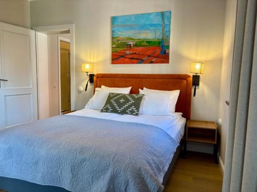 a bedroom with a bed and a painting on the wall at ToRUŃ ApartHotel z widokiem na Wisłę i Krzywą Wieżę in Toruń