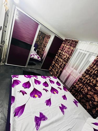 a bedroom with purple butterflies on a bed at Apartament CC in Drobeta-Turnu Severin