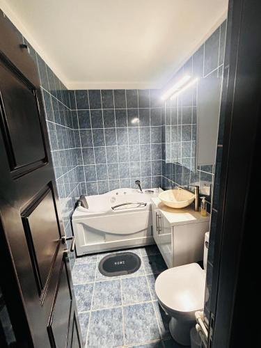 a bathroom with a tub and a toilet and a sink at Apartament CC in Drobeta-Turnu Severin
