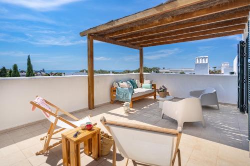 a patio with chairs and a couch on a roof at Villa Himala by 3VILLAS in Sant Lluis