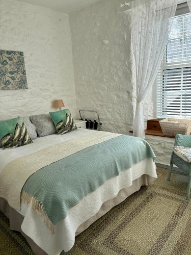 a bedroom with a large bed and a window at The Old Post House B&B in St. Just
