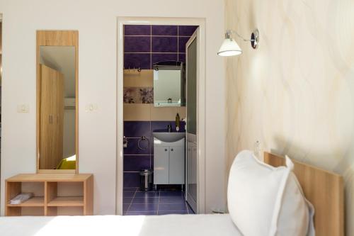a bedroom with a bed and a sink and a mirror at MARCONI GUESTHOUSE in Hunedoara