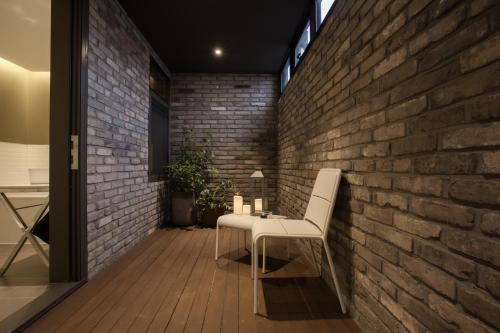 a brick wall with a bench and a table at Hotel Gaden in Suwon