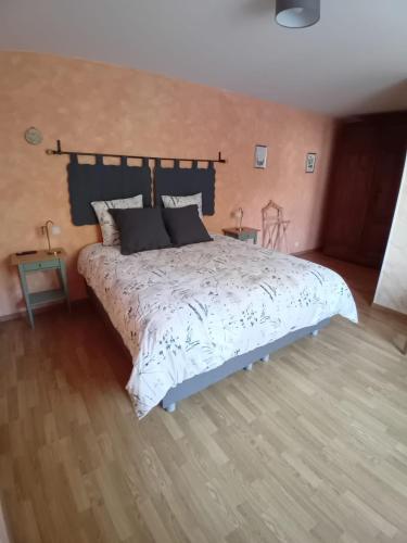 a bedroom with a large bed and two tables at Les Castelblotines in Châteaubleau