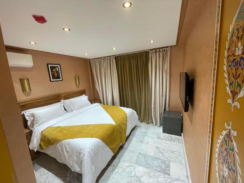 a hotel room with a bed and a television at Hotel Almas Meknes in Meknès