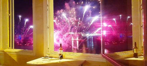 a window with two wine glasses and a fireworks display at Port 531 Savynomad Harbour Residences Valletta wow Views in Valletta