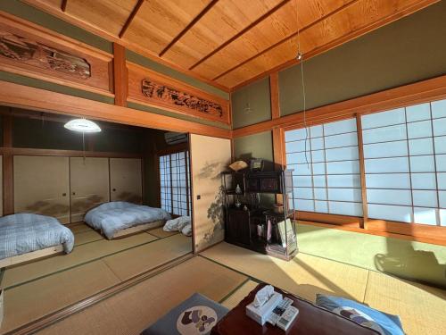 a room with two beds in a room with wooden ceilings at 和の宿 禅 in Nachikatsuura