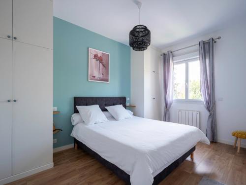 a bedroom with a large bed with blue walls at appartement 15min de Paris in Drancy