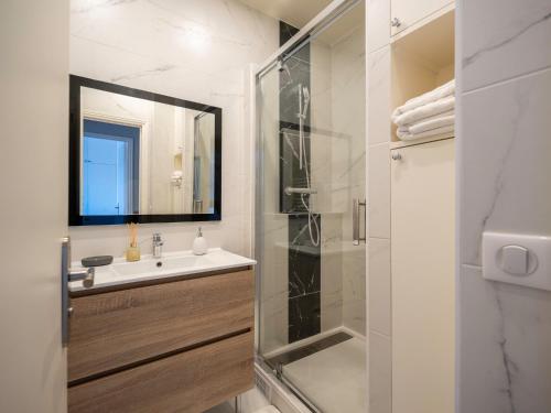 a bathroom with a sink and a glass shower at appartement 15min de Paris in Drancy