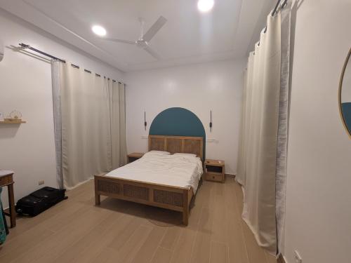 a bedroom with a bed in a room with curtains at Villa Hùéfa in Ouidah