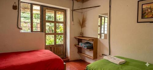 a bedroom with a red bed and a window at Coco's vibes in Ollantaytambo