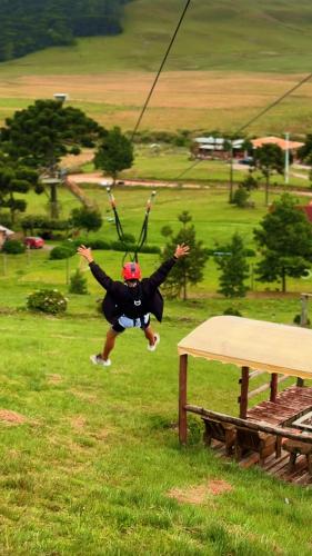 a person jumping in the air on a zip line at Parador Pôr do Sol in Cambará