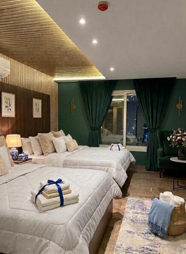 two beds in a room with green walls at Blue Pyramids Eyes Hotel in Cairo