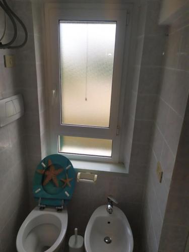a small bathroom with a toilet and a window at Casa delle Onde in Vada