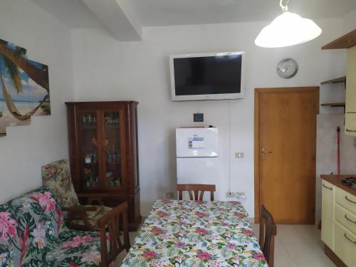 a room with a table and a kitchen with a refrigerator at Casa delle Onde in Vada