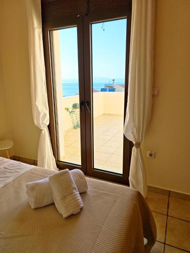 a bedroom with a bed with a view of the ocean at Vista Mare Aegina in Kipséli
