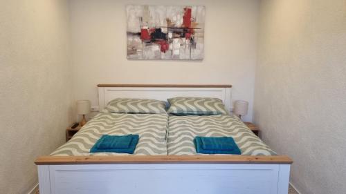 a bed with two blue pillows on it in a bedroom at Ferienhaus zum Wunschglockerl in Schrems