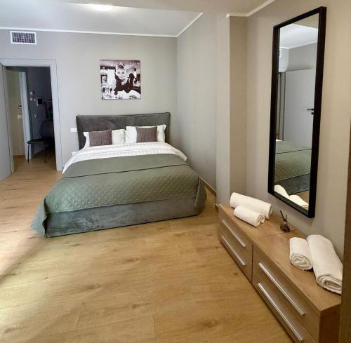 a bedroom with a large bed and a mirror at Casa Magenta Apartment 5 in Valeggio sul Mincio