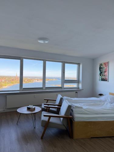 a bedroom with a bed and a chair and windows at Inselblick 3 in Schleswig