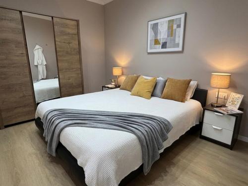 a bedroom with a large bed with two lamps and a mirror at Costa Ovest Apartment 3 in Nurachi
