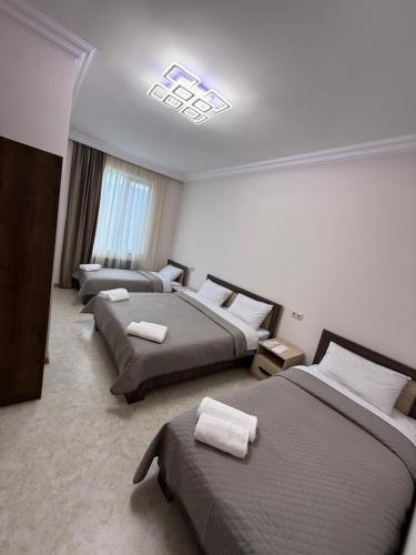 a hotel room with three beds and a chandelier at Guest House in Halidzor