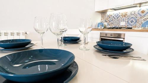 a kitchen counter with four bowls and wine glasses at Corte Nizza in Taviano
