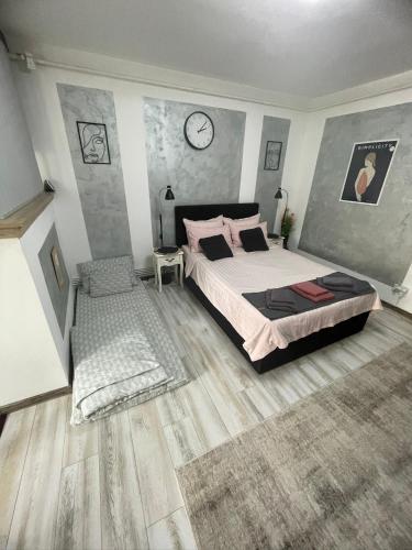 a bedroom with a bed and a clock on the wall at central studio LCS in Hunedoara