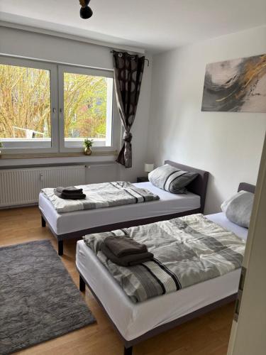 two beds in a room with a window at Rethmann Monteurwohnung Ferienwohung in Georgsmarienhütte
