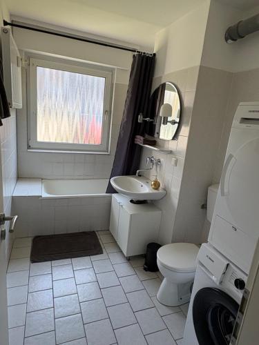 a bathroom with a sink toilet and a window at Rethmann Monteurwohnung Ferienwohung in Georgsmarienhütte