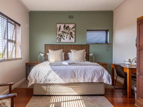 a bedroom with a bed and a desk and window at Harewood Lodge in East London