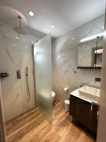 a bathroom with a shower and a sink and a toilet at Oleana Grand Appartment in Lampi