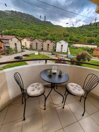 a table and two chairs on a balcony with a view at Elena Apartment in Plužine