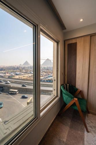 a green chair in a room with a large window at Blue Pyramids Eyes Hotel in Cairo