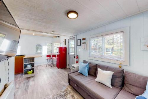 a living room with a couch and a red refrigerator at Lighthouse at Evergreen Resort in WB in Wasaga Beach