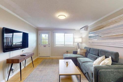 a living room with a blue couch and a tv at Beachy Daze in Wasaga Beach in Wasaga Beach