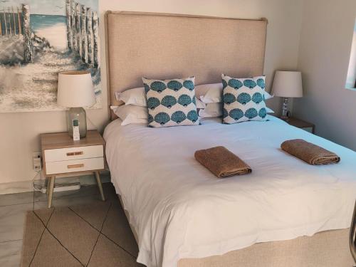 a bedroom with a bed with two pillows on it at Mtunzini South Cottage in Mtunzini