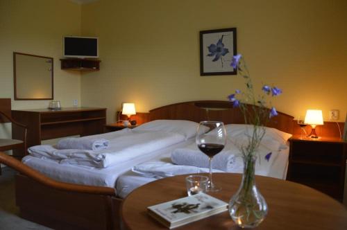 a hotel room with a bed and a table with wine glasses at Renerovka 93 in Dolní Malá Úpa