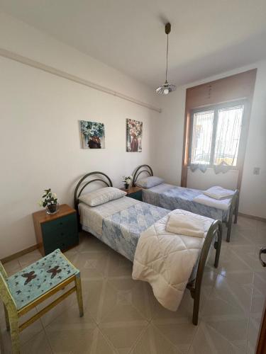 a bedroom with three beds and a table and a chair at Amata Villa Vacanza in Leuca