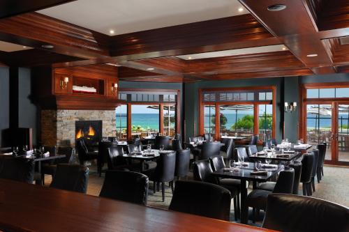 a dining room with tables and chairs and a fireplace at Inn at Bay Harbor in Petoskey