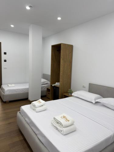 a bedroom with two beds with towels on them at Petro Rooms and View in Laç