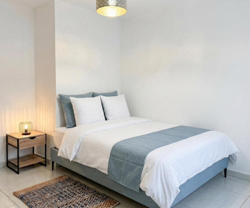 a bedroom with a bed with a blue and white bedspread at Location meublee Kourou pour 5 personnes plus 1 bebe in Kourou