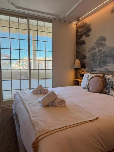 a bedroom with a large bed with towels on it at The Suite Collection in Fuengirola
