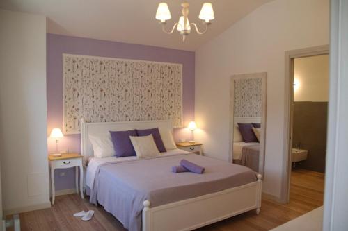 a bedroom with a large bed with purple accents at Casa MaeVi in Galzignano