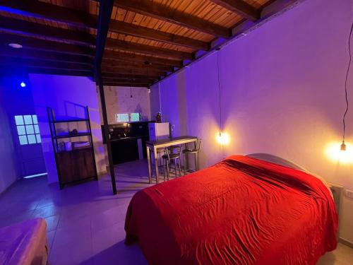 a bedroom with a red bed and a table at La Bodeguita in Trinidad